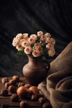 Natürmort ceviz, armut ve gül ahşap masa üzerinde