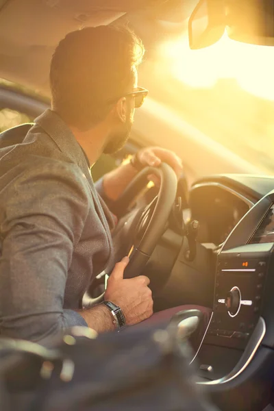 Handsome man in the car in sunlight