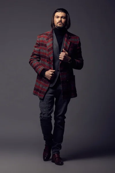 Красивий чоловік в стильній куртці позує в студії — стокове фото