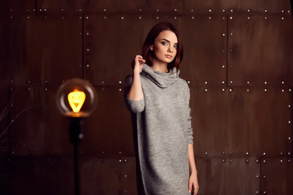 Jovem modelo bonito posando em estúdio em vestido cinza — Fotografia de Stock