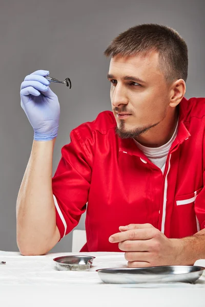 Doctor looks at leech on medical instrument — Stock fotografie