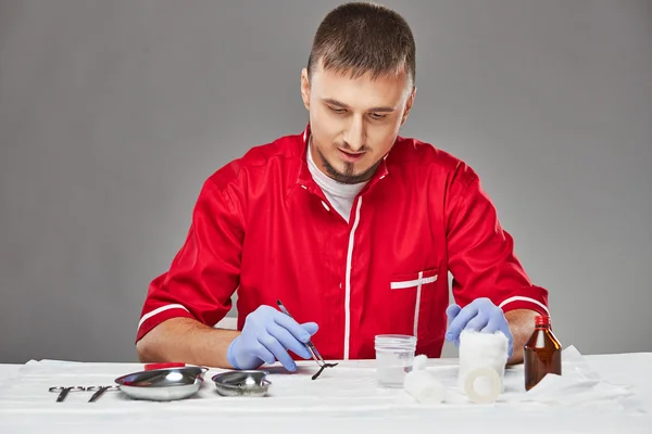 Pharmacist looks at leech with medical instrument — Stock fotografie