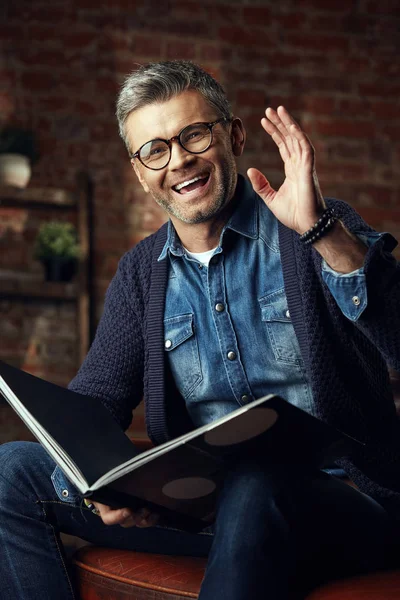 Retrato de hombre atractivo en gafas con pelo gris en estudio loft con un libro — Foto de Stock