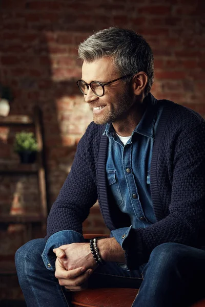 Retrato de hombre de negocios con estilo con pelo gris y gafas en el estudio loft mirando hacia otro lado y sonriendo — Foto de Stock