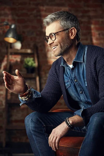 Retrato de hombre de negocios con estilo con pelo gris y gafas en el estudio loft mirando hacia otro lado y hablando — Foto de Stock