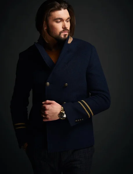 Привабливий стильний чоловік з довгим волоссям в темній студії в класичному синьому піджаку — стокове фото