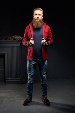 Karanlık studio giymiş, uzun sakallı çekici adam kırmızı ceket
