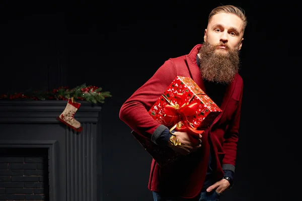 Handsome stylish bearded man in studio with red box in his hands — Stock Photo, Image