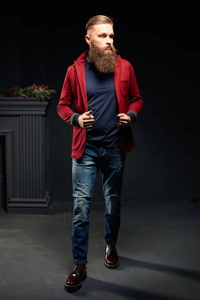 Young model man with long beard standing in dark studio — Stock Photo, Image