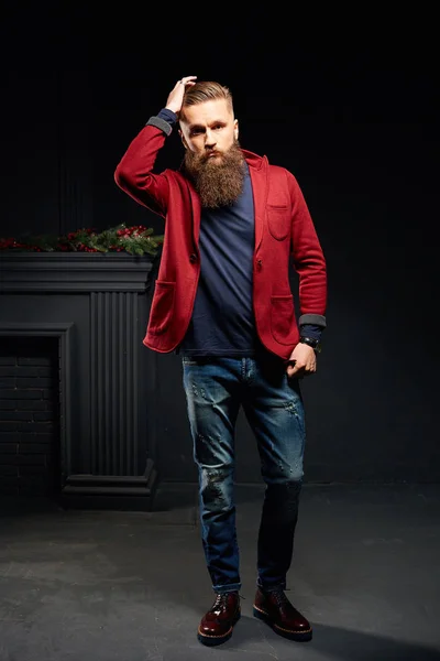 Привабливий чоловік з довгою бородою, що стоїть в темній студії — стокове фото