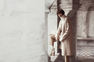 Çekici kadın arka plan üzerinde büyük mimari ile hafif giysiler içinde poz