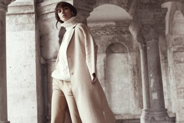 Arka plan üzerinde büyük mimari ile hafif giysiler içinde poz çekici model erkek