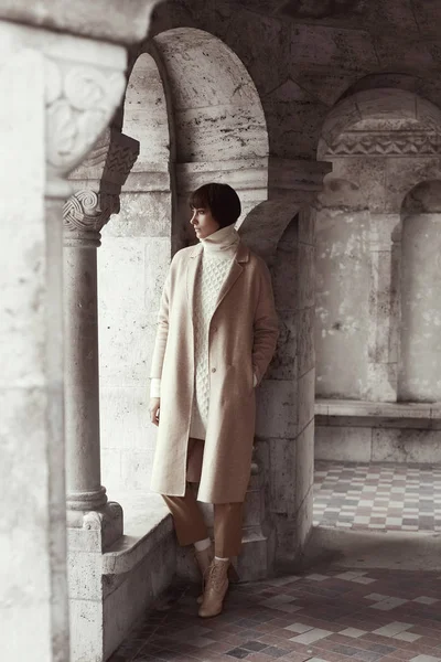 Привлекательная модель женщина позирует в легкой одежде с великолепной архитектурой на заднем плане — стоковое фото