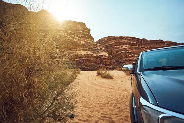 ภูมิทัศน์หินแดดและรถคันใหญ่ในทะเลทราย Wadi Rum ในอาระเบีย — ภาพถ่ายสต็อก