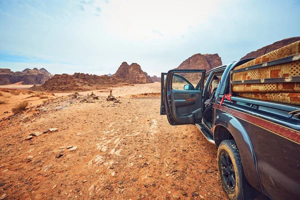 มุมมองที่ดีกับหินสีแดงและรถในทะเลทราย Wadi Rum ในจอร์แดน — ภาพถ่ายสต็อก