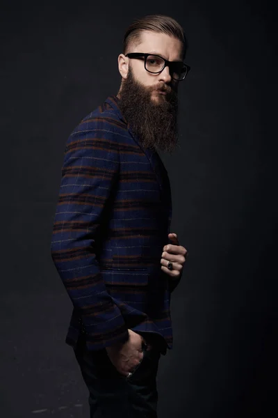 Bellissimo uomo elegante con barba in studio scuro — Foto Stock