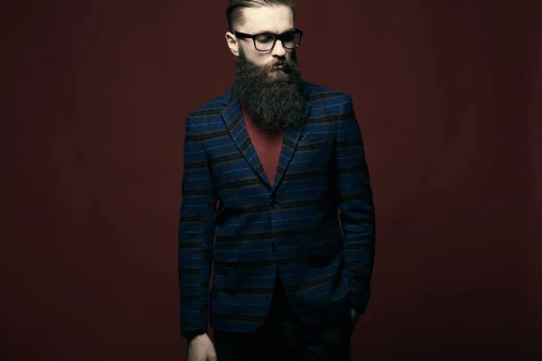 Porträt eines ernsten, stylischen Mannes mit Bart und Brille im dunklen Studio — Stockfoto