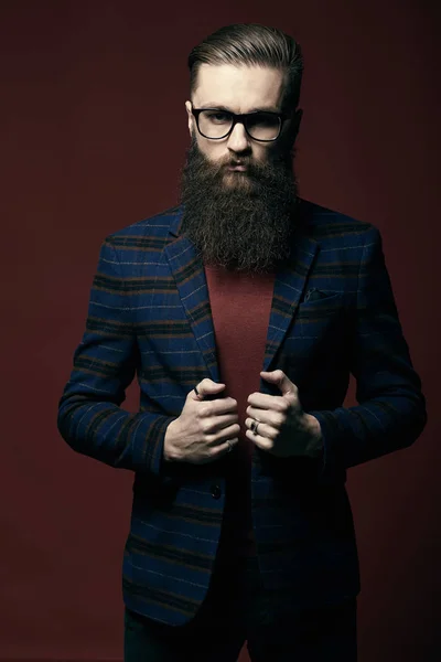 Retrato de un hombre serio y elegante con barba en un estudio oscuro —  Fotos de Stock