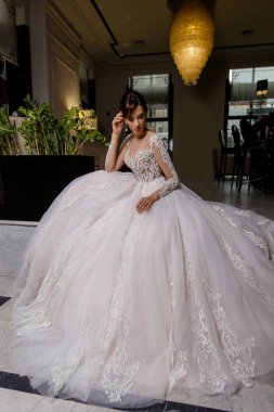 Yetişkin genç esmer model kadın teşkil etmektedir moda zemin üzerine dantel ile uzun gelin elbise