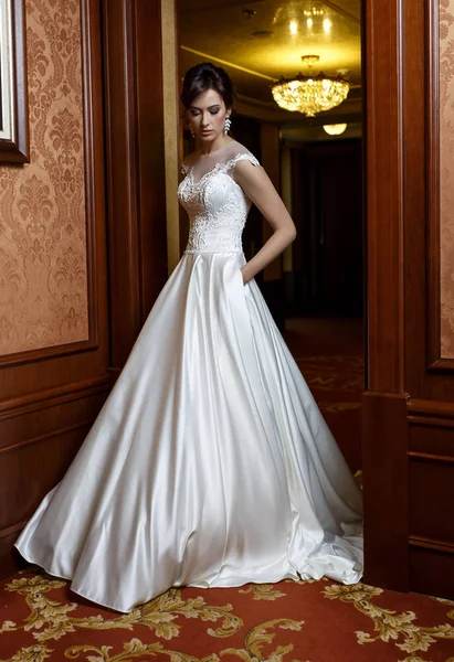 Mooie vrouw in luxe bruids jurk binnen — Stockfoto