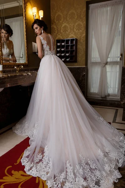 Schöne Frau in Luxus-Hochzeitskleid mit Spitze auf Glamour-Hintergrund — Stockfoto