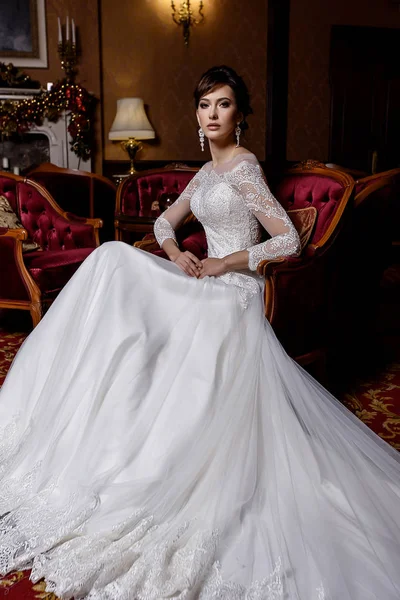 Junges Model posiert in bezauberndem langen Brautkleid mit Spitze auf elegantem Hintergrund — Stockfoto