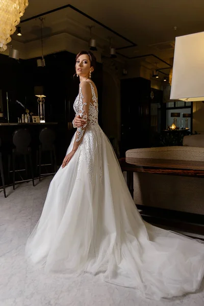 Atraente jovem morena modelo feminino poses em vestido de noiva longo com renda no fundo da moda — Fotografia de Stock