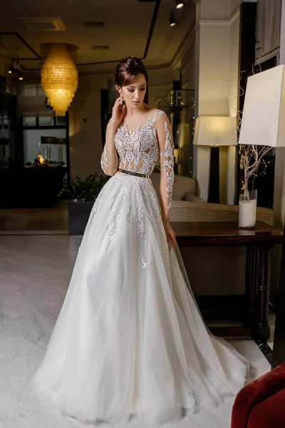 Güzel genç esmer modeli kadın teşkil etmektedir moda zemin üzerine dantel ile uzun gelin elbise