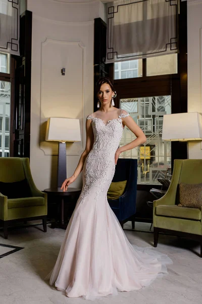 Uzun gelinlik dantel moda arka plan üzerinde ile ciddi genç esmer modeli kadın pozlar