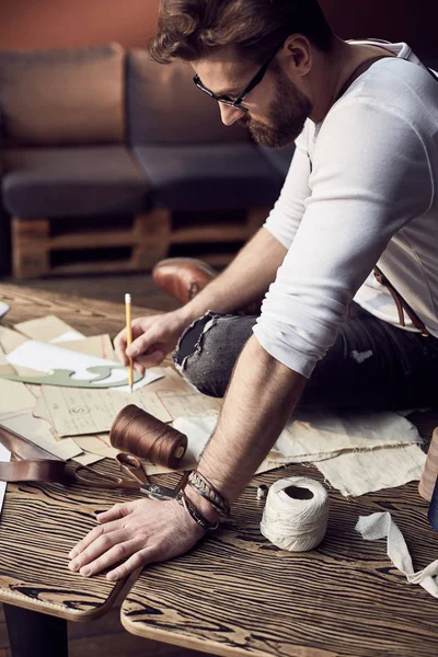 Szép török férfi szakáll és poharak a barna bőr harisnyatartó közeledik fából készült asztal, szálat és olló csodálatos műtermében, antik bútorokkal, fehér ing — Stock Fotó