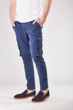 Trendy koyu mavi pantolon cepleri ve siyah ayakkabılar ile ışık Studio duran adam