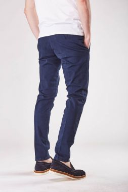 Adam sırtını trendy koyu mavi chinos ve siyah ayakkabılar Işık Studio gösterilen