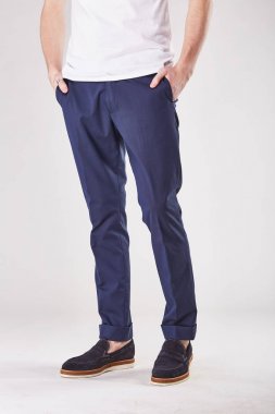 Adam trendy koyu mavi chinos ve siyah ayakkabılar Işık Studio poz