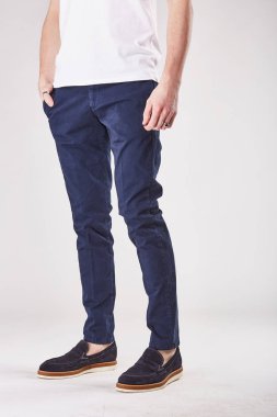 Adam trendy koyu mavi chinos ve siyah ayakkabılar Işık Studio poz
