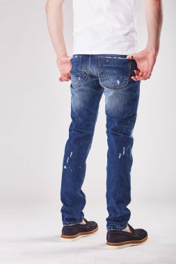 Adam içeri ışık stüdyo trendy koyu mavi kot kot pantolon ve siyah ayakkabılar gösterilen