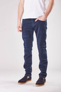 Adam trendy koyu mavi kot kot pantolon ve siyah ayakkabı Işık Studio poz