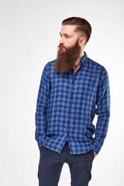 Genç adam Studio trendy mavi kareli gömlek ve Mavi pantolon poz sakallı