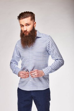 Mavi çizgili ve Mavi pantolon ile sevimli beyaz gömlek Studio poz adam genç sakallı