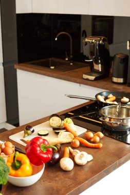 Natürmort renkli sebze ve yumurta, bıçak ve modern teknoloji mutfak masasının üzerinde kesme tahtası