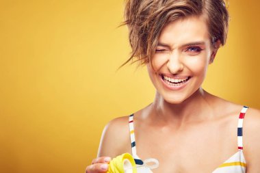 Portre portre Studio Sarı zemin üzerine poz geniş güler yüz ile kısa darmadağınık kahverengi saçlı seksi genç güzel kadın modeli