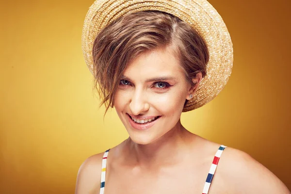 Closeup portrait of sexy young pretty woman with short disheveled brown hair, looking happy, wearing straw hat, posing in studio on yellow background — Stock Photo, Image