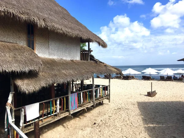 Belle vue sur la côte océanique, plage de sable avec parasols blancs et chalet avec toit en paille, sur l'île asiatique — Photo