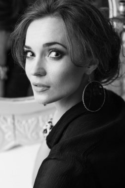 Portre portre olan göz alıcı makyaj, siyah ve beyaz aynaya yakın oturan genç çekici esmer kadın