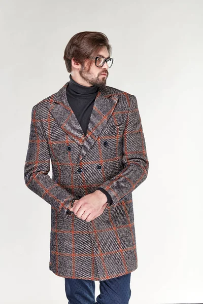 Sakal ve gözlük gri kareli kaşmir palto ve koyu mavi pantolon Işık Studio poz ile çekici genç seksi ciddi adam modeli 