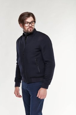 Sakal ve gözlük ile fermuar ve Işık Studio koyu mavi pantolon koyu renk ceketli poz ile çekici genç seksi erkek modeli 