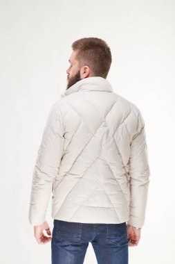 Hafif bir ceket ve koyu mavi jeans Işık Studio poz sakallı yakışıklı genç seksi erkek modeli 