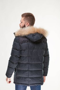 Karanlık kış ceket ve koyu mavi pantolon Işık Studio poz sakallı yakışıklı genç seksi erkek modeli 