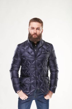 Çekici genç seksi erkek model mavi sıcak ceket ve kot Işık Studio poz sakallı 