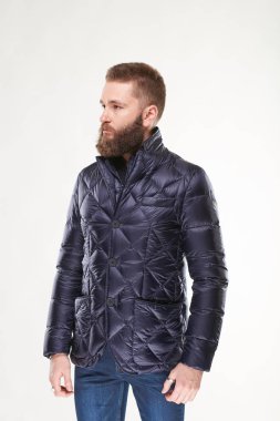 Koyu mavi kış ceket ve koyu mavi jeans Işık Studio poz sakallı yakışıklı genç modeli 