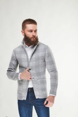 Çekici genç seksi ciddi adam modeli gri ceket, beyaz gömlek ve koyu mavi pantolon Işık Studio poz sakallı 